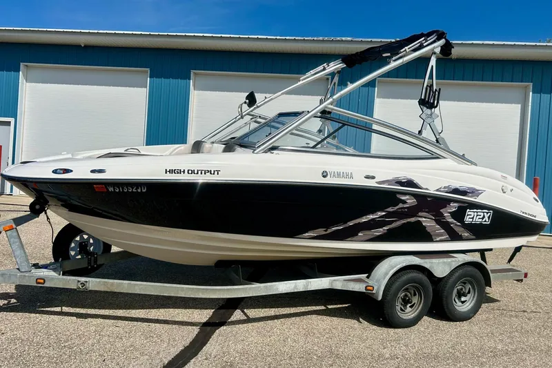 Slide: The Image of 2008 Yamaha 212X boat on trailer, parked outside blue building. - 30