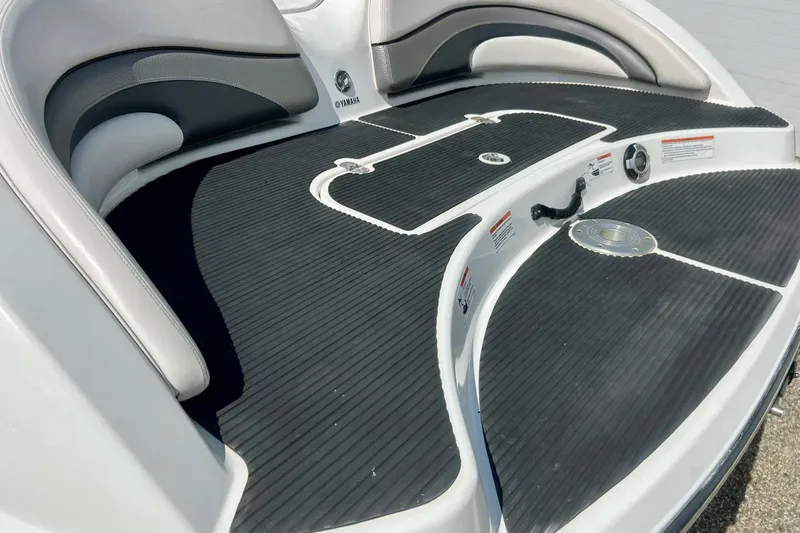 Slide: The Image of 2008 Yamaha 212X boat interior with black non-slip flooring and cushioned seating. - 32