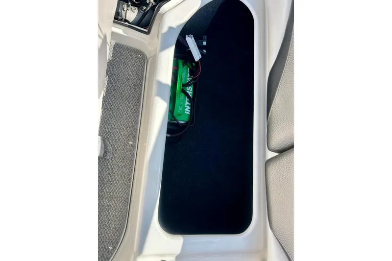 Slide: The Image of Storage compartment in a 2008 Yamaha 212X boat, featuring a battery and carpeted interior. - 33
