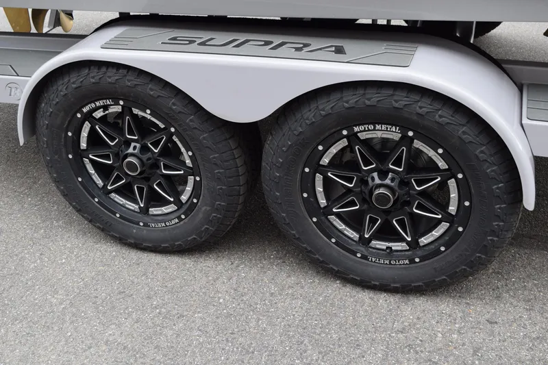 Slide: The Image of 2025 Supra SA trailer with dual Moto Metal wheels on asphalt. - 10