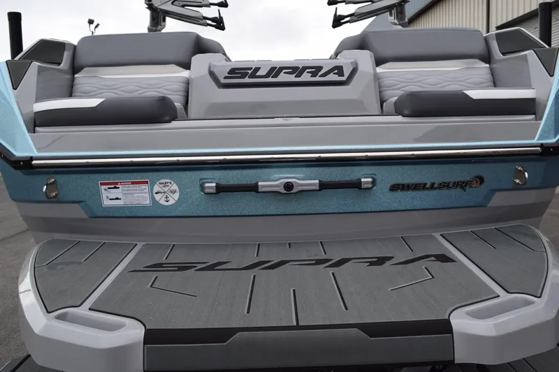 Slide: The Image of 2025 Supra SA boat rear view with SwellSurf technology and cushioned seating. - 12