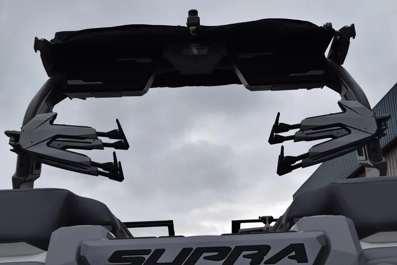Slide: The Image of 2025 Supra SA boat tower with wakeboard racks against cloudy sky. - 9