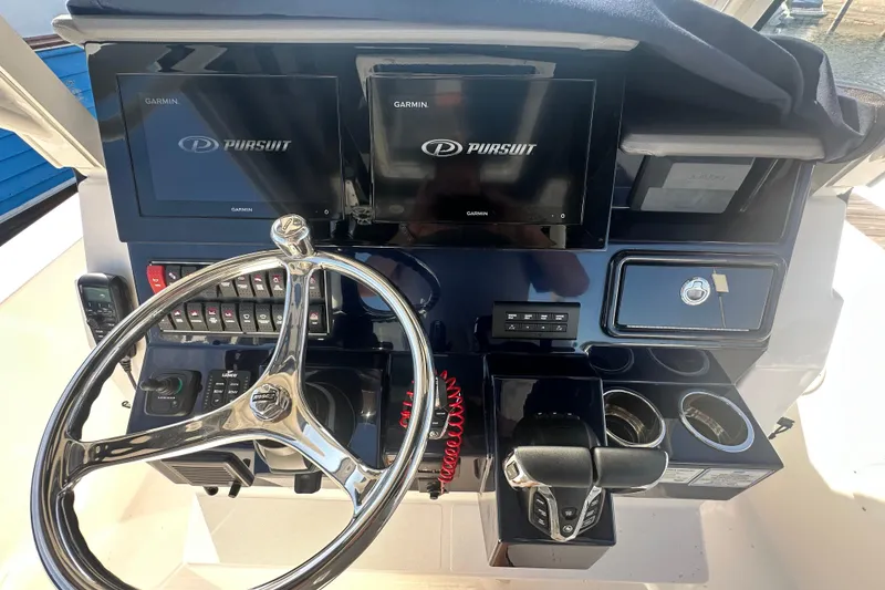 Slide: The Image of 2024 Pursuit S 288 Sport boat dashboard with Garmin displays and steering wheel. - 10