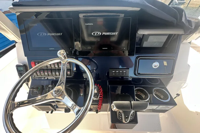 Slide: The Image of 2024 Pursuit S 288 Sport boat dashboard with Garmin displays and steering wheel. - 11
