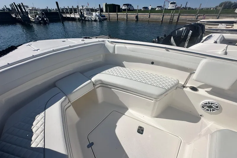 Slide: The Image of 2024 Pursuit S 288 Sport boat interior with cushioned seating and speaker. - 16