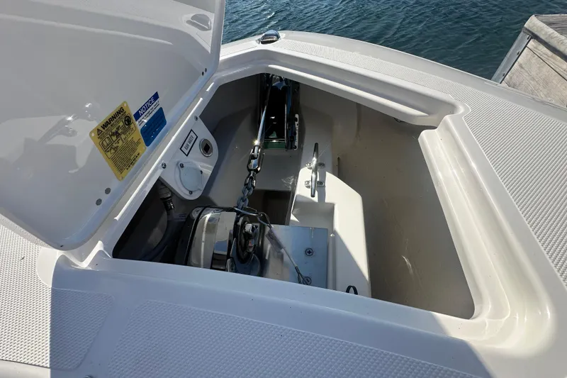 Slide: The Image of 2024 Pursuit S 288 Sport boat anchor compartment with open hatch, dockside view. - 17
