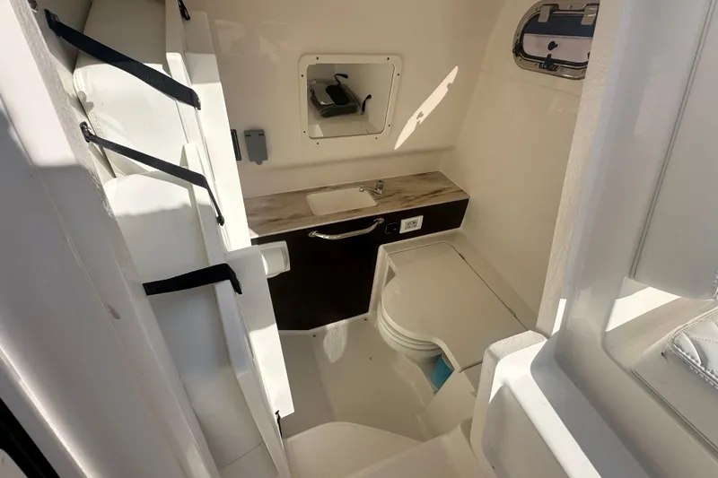 Slide: The Image of 2024 Pursuit S 288 Sport boat interior with compact bathroom and sink. - 19