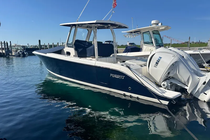 Slide: The Image of 2024 Pursuit S 288 Sport boat docked with Yamaha engines, clear blue water. - 2