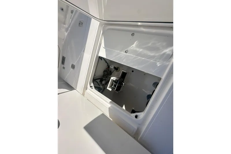 Slide: The Image of 2024 Pursuit S 288 Sport boat storage compartment with open hatch, showcasing interior details. - 21