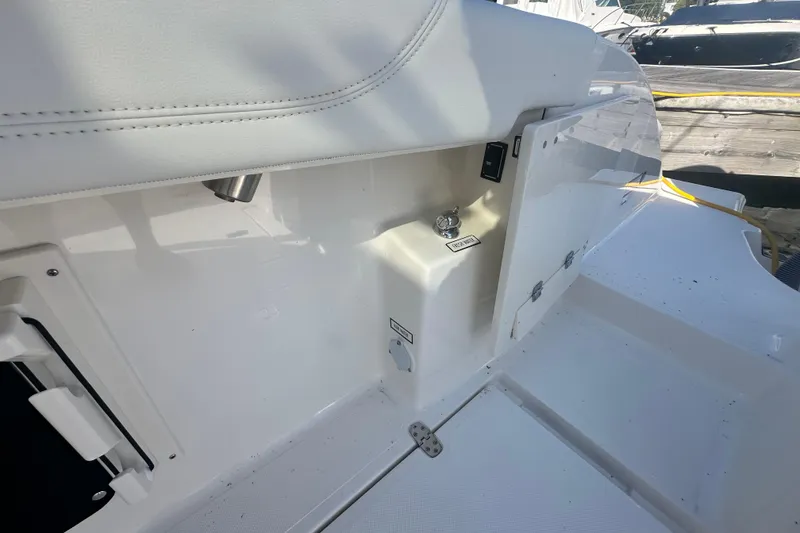 Slide: The Image of 2024 Pursuit S 288 Sport boat interior detail with white seating and storage compartments. - 22