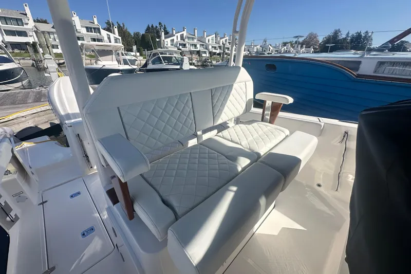 Slide: The Image of 2024 Pursuit S 288 Sport boat with luxurious seating in a marina setting. - 7