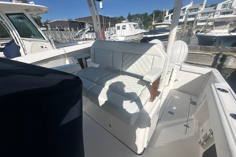 Slide: The Image of 2024 Pursuit S 288 Sport boat with white seating at a marina. - 8