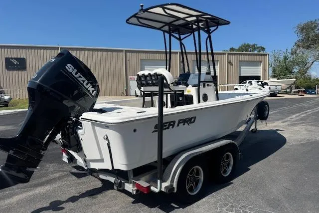 The Image of 2024 Sea Pro 210 Bay boat on trailer, parked outdoors under clear sky. - 0