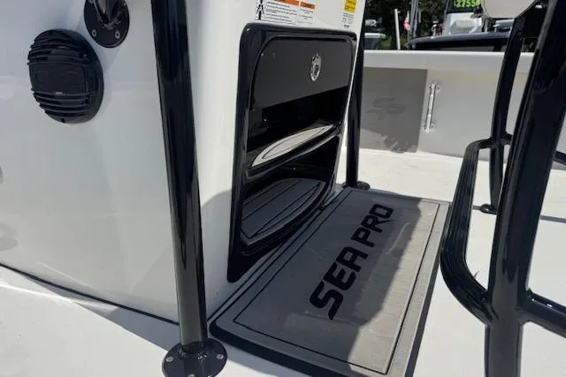 Slide: The Image of 2024 Sea Pro 210 Bay boat interior with branded mat and storage compartment. - 11