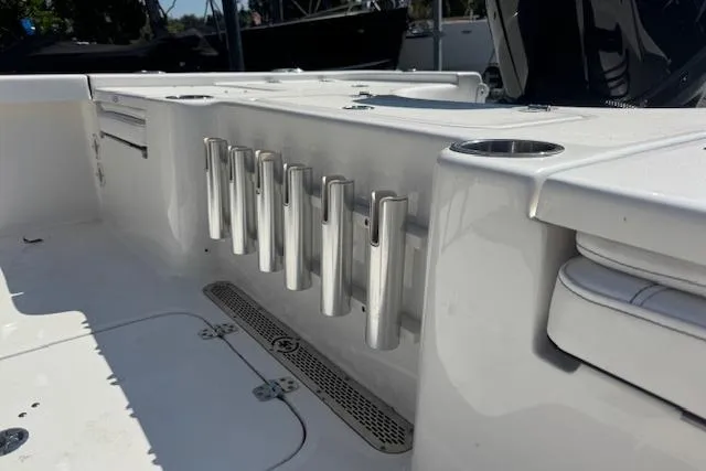 Slide: The Image of 2024 Sea Pro 210 Bay boat interior with rod holders and storage compartments. - 12