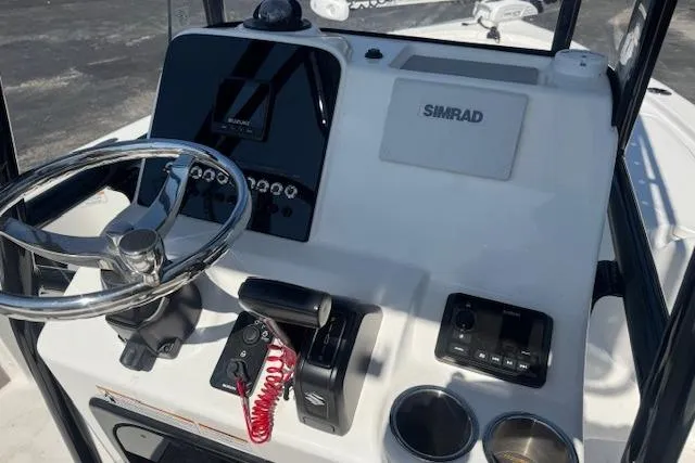Slide: The Image of 2024 Sea Pro 210 Bay boat console with steering wheel, Simrad display, and controls. - 15