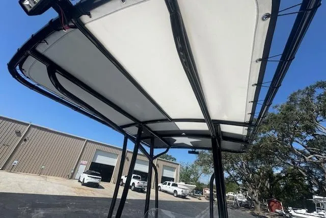 Slide: The Image of 2024 Sea Pro 210 Bay boat with T-top, parked near industrial buildings. - 17