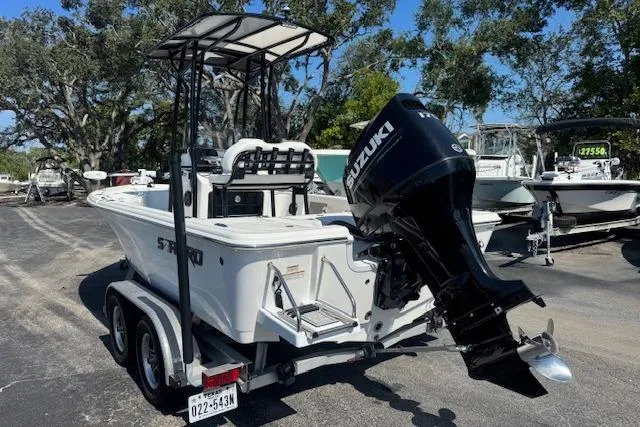 Slide: The Image of 2024 Sea Pro 210 Bay boat with Suzuki engine on trailer, parked outdoors. - 3