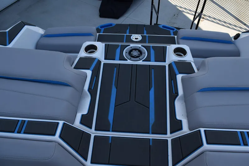 The Image of 2026 Supra SA boat in showroom, white and blue design, on trailer. - 10