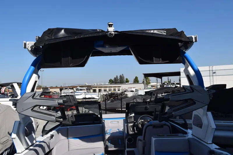 Slide: The Image of 2026 Supra SA boat in showroom, white and blue design, on trailer. - 12