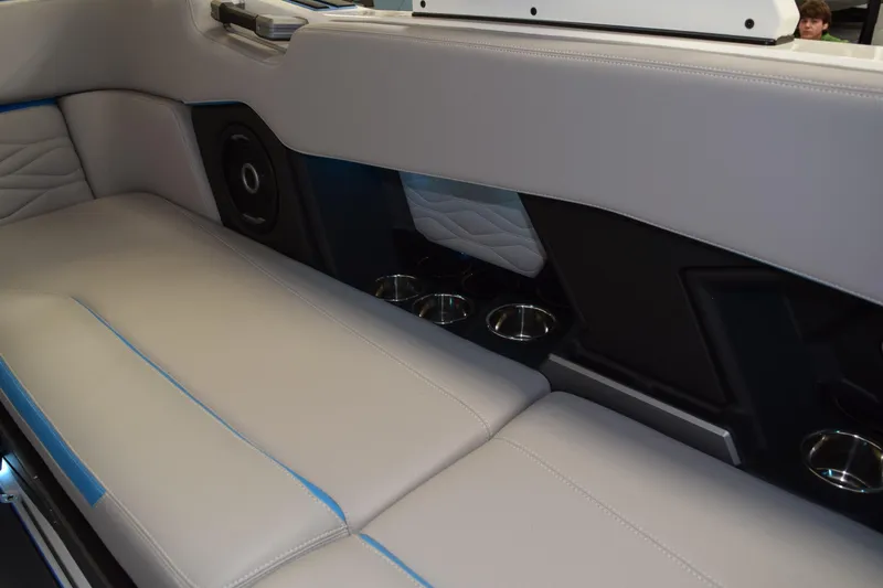 Slide: The Image of 2026 Supra SA boat interior with gray seating, cup holders, and speaker system. - 20