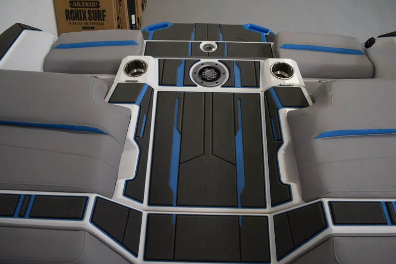 Slide: The Image of 2026 Supra SA boat interior with gray and blue seating and cup holders. - 21