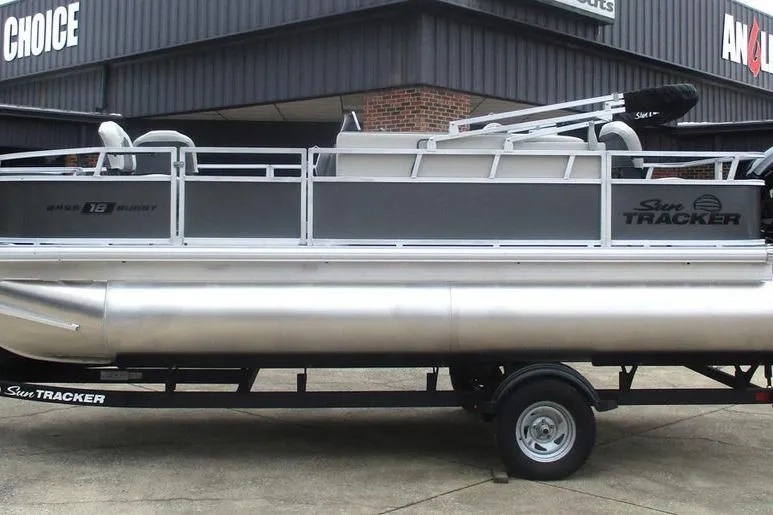 The Image of 2026 Sun Tracker Bass Buggy 18 DLX pontoon boat on trailer, parked outside dealership. - 0
