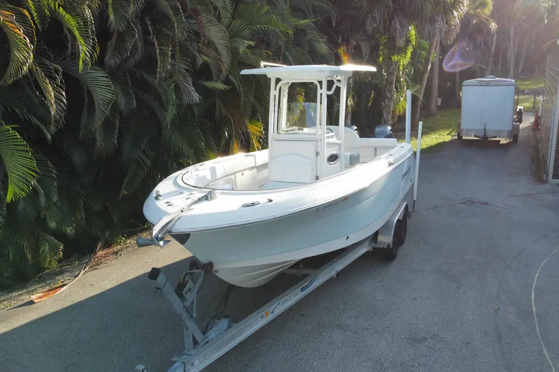 Slide: The Image of 2020 Robalo Center Console boat on trailer, surrounded by lush greenery. - 10
