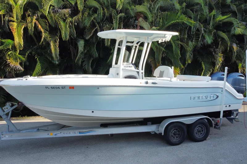 Slide: The Image of 2020 Robalo Center Console boat with spacious seating, parked near lush greenery. - 14