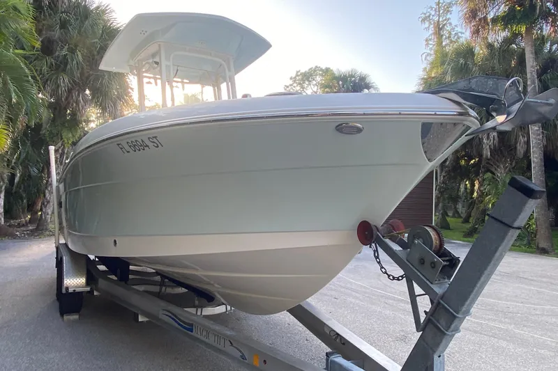Slide: The Image of 2020 Robalo Center Console boat on trailer, surrounded by trees. - 2