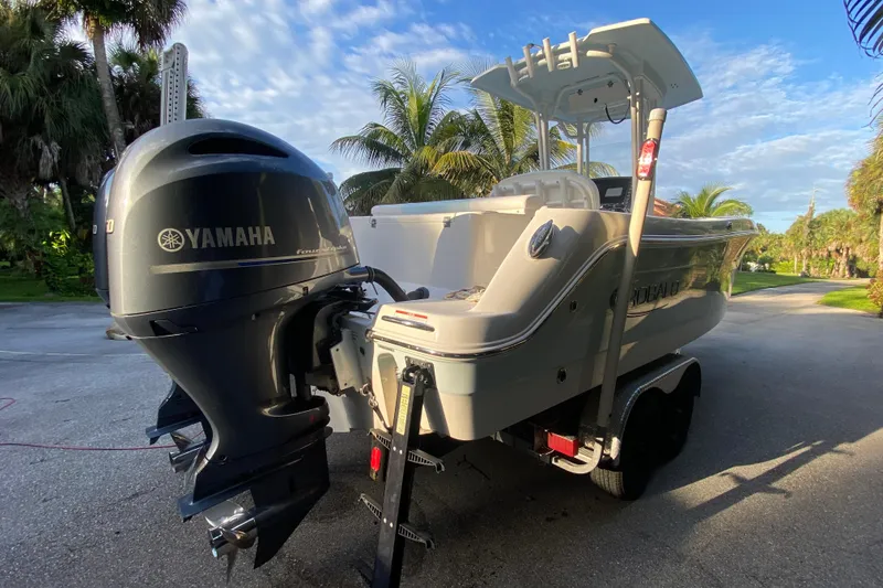 Slide: The Image of 2020 Robalo Center Console boat with dual Yamaha 150 engines, parked on a sunny driveway. - 24