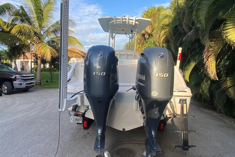 Slide: The Image of 2020 Robalo Center Console boat with dual outboard motors, parked on a driveway. - 26