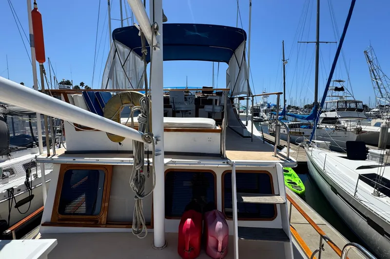 Slide: The Image of 1980 Californian Tri-Cabin Trawler docked at marina, featuring upper deck and nautical equipment. - 11