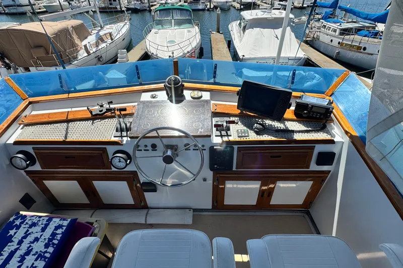 Slide: The Image of 1980 Californian Tri-Cabin Trawler helm with navigation equipment, docked at marina. - 13