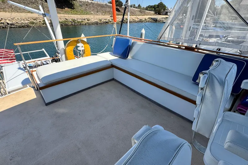 Slide: The Image of 1980 Californian Tri-Cabin Trawler deck with cushioned seating and scenic water view. - 17