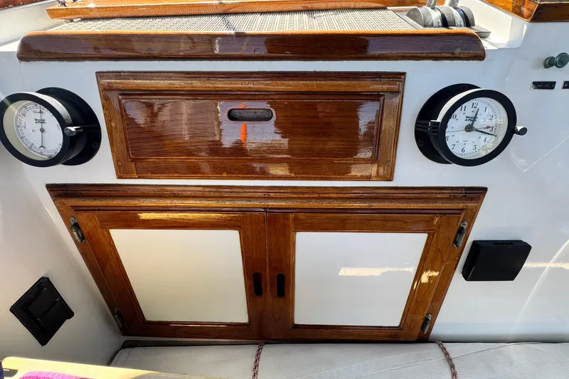 Slide: The Image of 1980 Californian Tri-Cabin Trawler interior with wooden cabinetry and nautical instruments. - 18