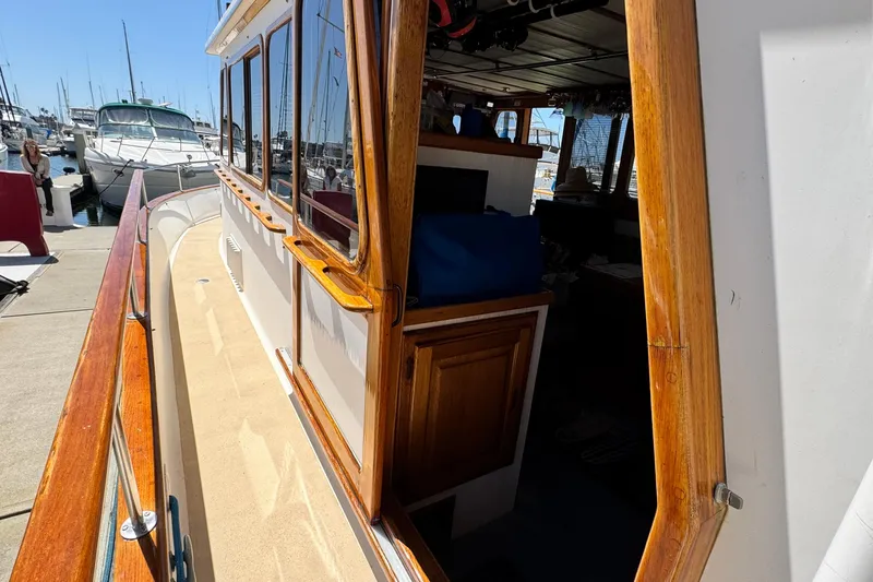Slide: The Image of 1980 Californian Tri-Cabin Trawler docked, showcasing wooden trim and cabin interior. - 22