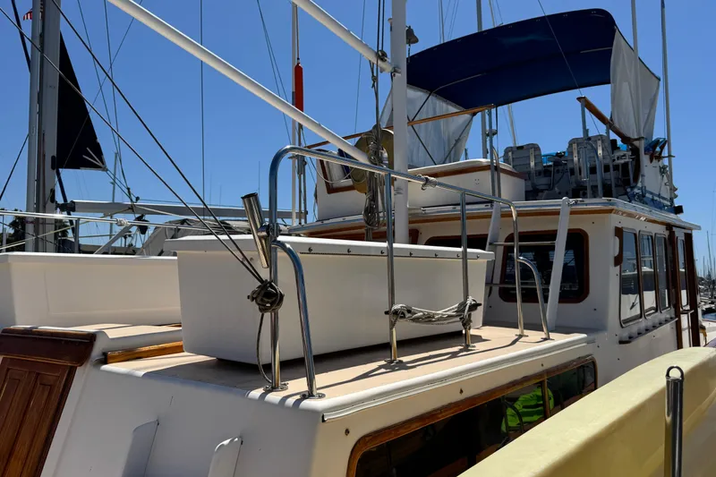 Slide: The Image of 1980 Californian Tri-Cabin Trawler with deck view, featuring railings and nautical equipment. - 27
