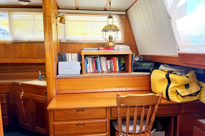 Slide: The Image of 1980 Californian 42 LRC yacht interior with wooden desk, books, and nautical decor. - 36