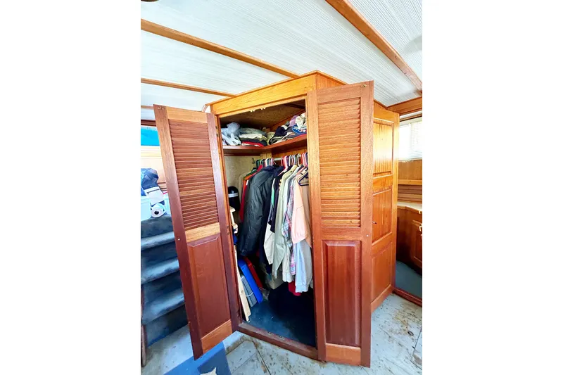 Slide: The Image of Wooden closet with clothes inside on a 1980 Californian 42 LRC boat. - 38