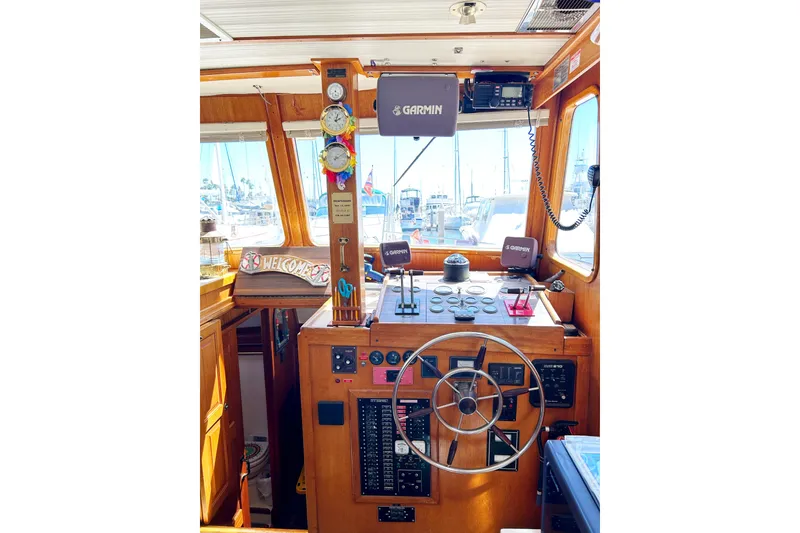 Slide: The Image of 1980 Californian 42 LRC yacht helm with Garmin navigation, wooden interior, and nautical instruments. - 46
