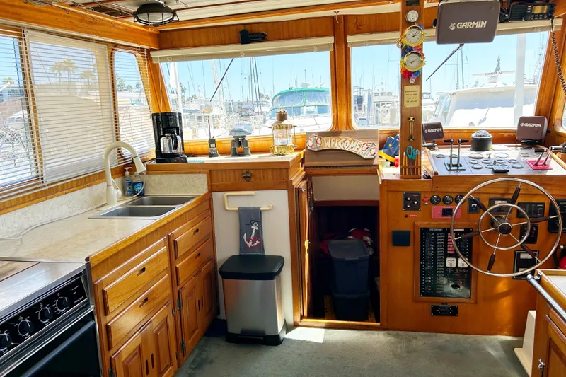 Slide: The Image of Interior of 1980 Californian 42 LRC yacht with kitchen and helm, featuring wood cabinetry. - 47