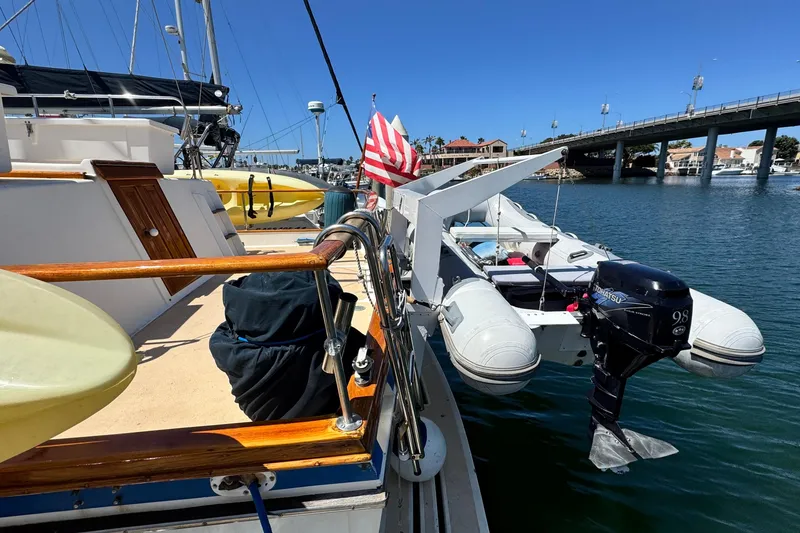 Slide: The Image of 1980 Californian Tri-Cabin Trawler docked with inflatable boat and American flag. - 5