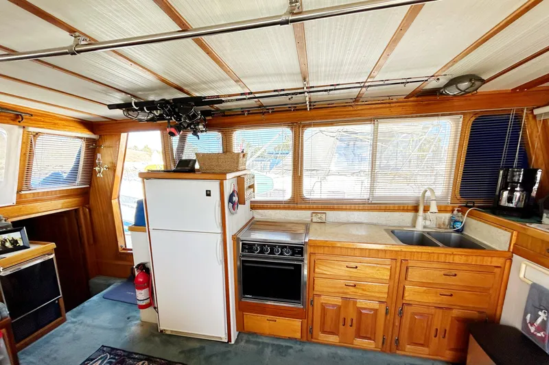 Slide: The Image of Interior of 1980 Californian 42 LRC yacht with kitchen, wooden cabinets, and fishing rods. - 58
