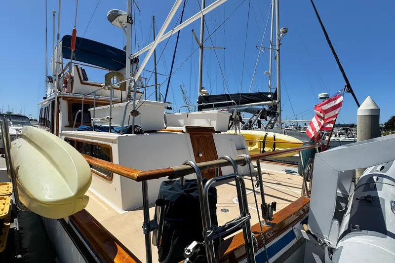 Slide: The Image of 1980 Californian Tri-Cabin Trawler docked with American flag and kayak on deck. - 7