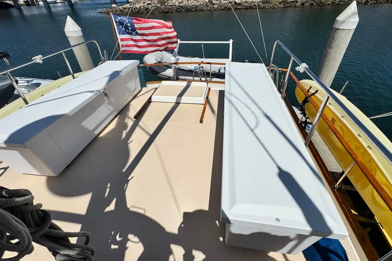Slide: The Image of 1980 Californian Tri-Cabin Trawler deck with storage benches and American flag. - 8