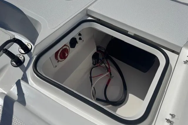 Slide: The Image of Open storage compartment on 2026 Frontier 2104 boat with wiring and controls. - 19