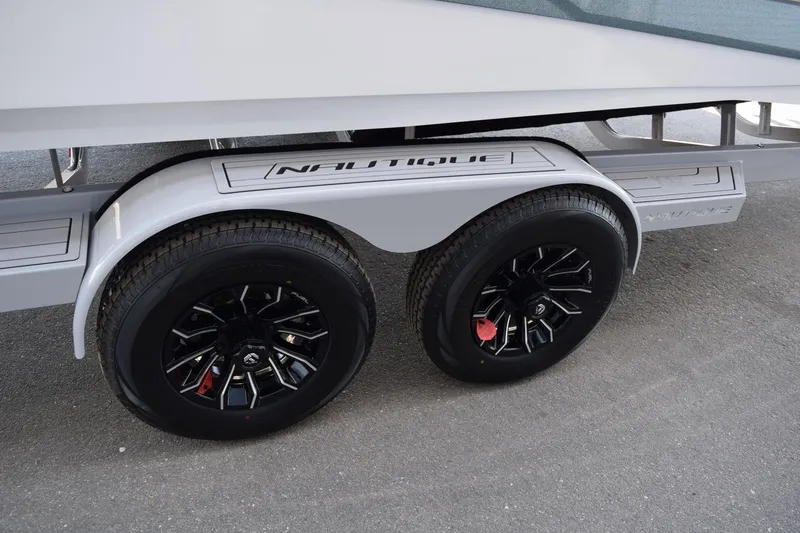 Slide: The Image of 2025 Nautique Super Air Nautique G23 Paragon trailer with sleek black wheels. - 22