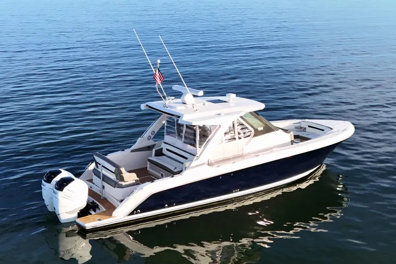 Slide: The Image of 2022 Tiara Yachts 34 LS boat on calm water, featuring sleek design and dual engines. - 11