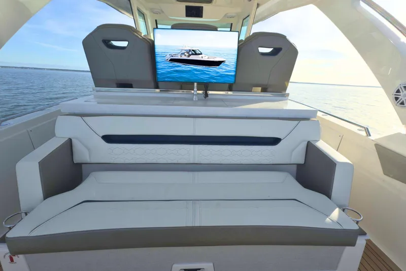 Slide: The Image of 2022 Tiara Yachts 34 LS interior with seating and TV, overlooking the ocean. - 18